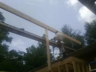 Carpenter setting a ridge beam over a new addition frame — Ice Dam Removal by Roofing Brothers in Rego Park