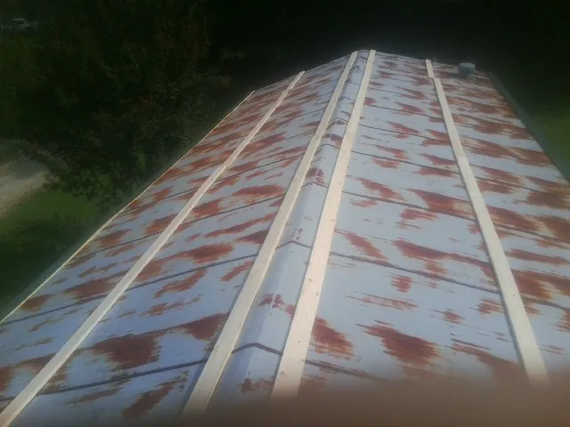Rusted metal roof panels with new wood purlins before replacement — Storm Damage Roof Repair in Rego Park by Roofing Brothers