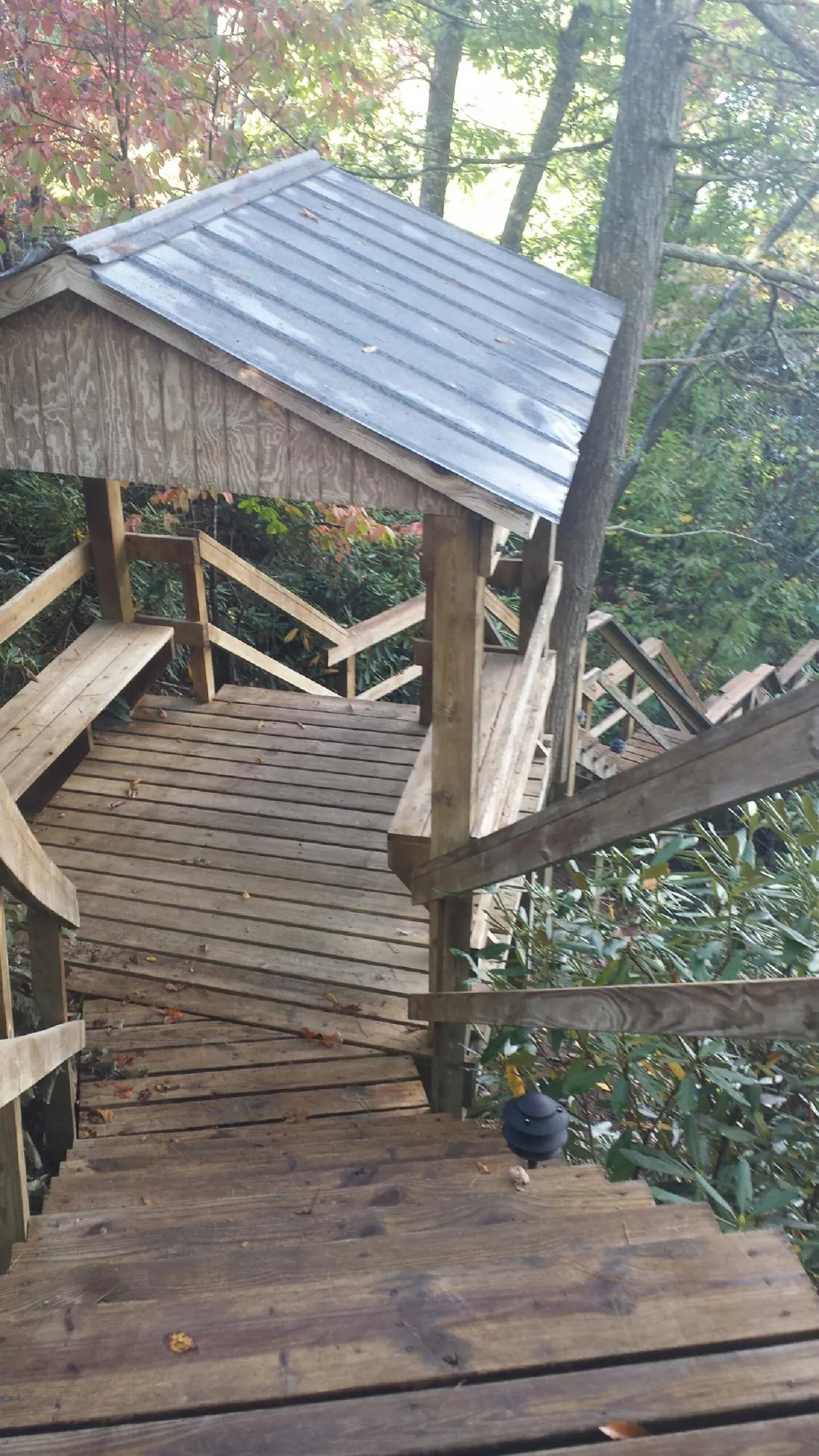 Metal roofed shelter over wooden steps on a wooded walkway — Skylight Repair & Installation work by our crew in Rego Park