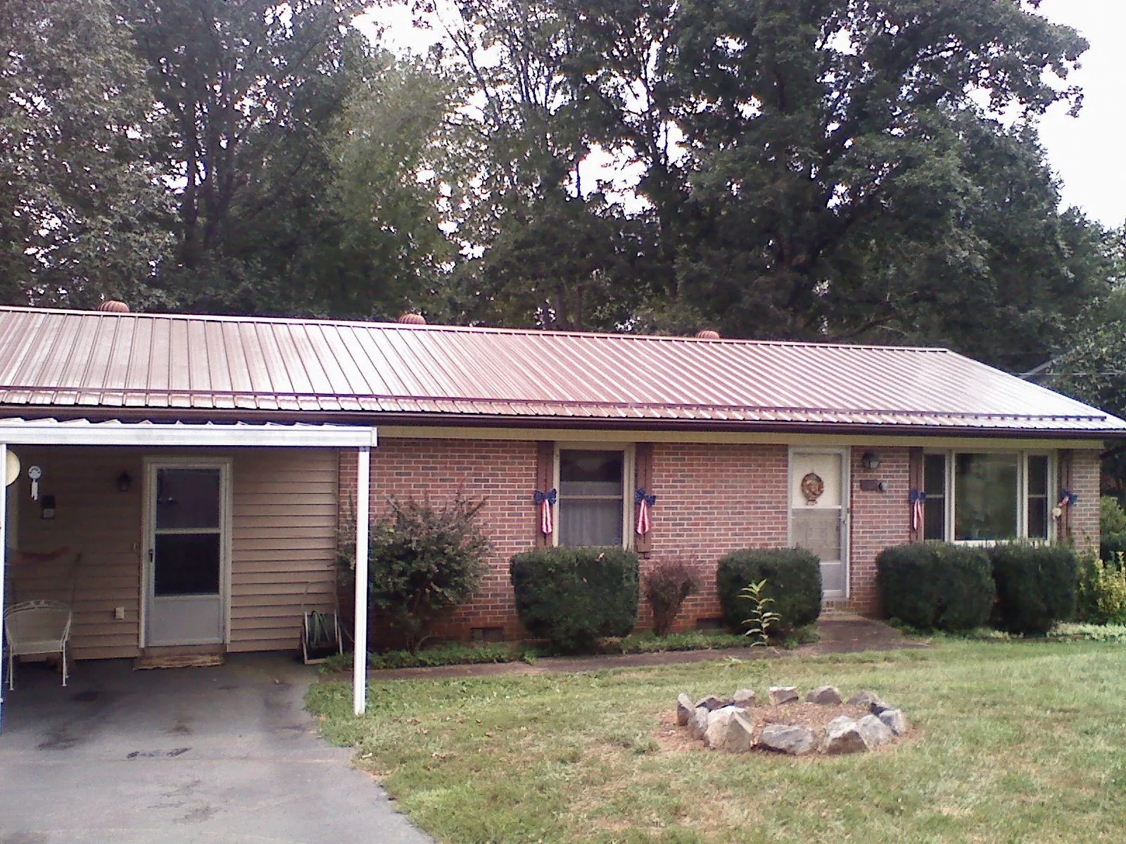 Bronze metal roof and carport on a brick ranch home — Roof Repair work by our crew in Rego Park